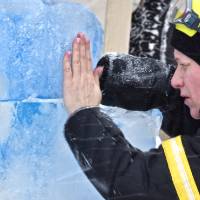 person placing hand on ice sculpture